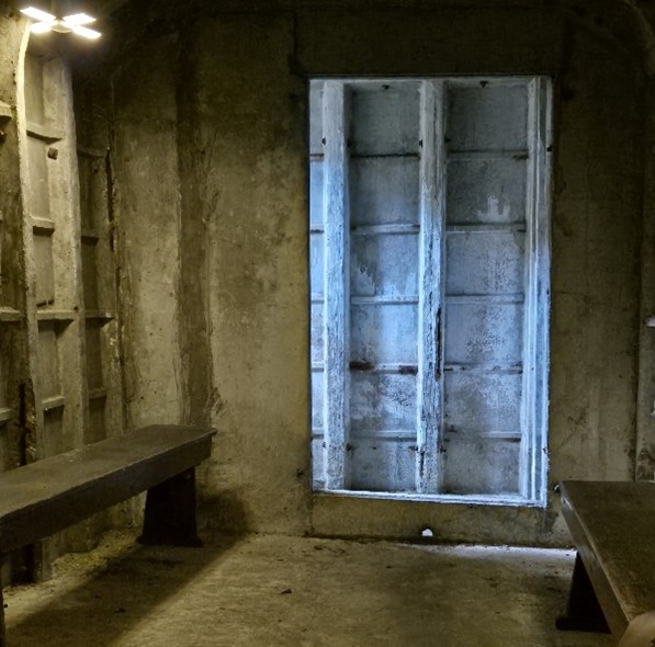 Dimly lit, bare underground bunker