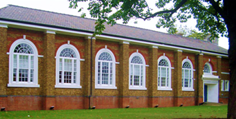attractive single story red brick building with a line of large white windows