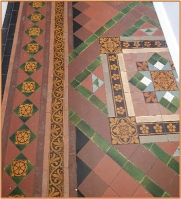 Fancy multicoloured tiles laid in patterns, some of which are decorated with scrollwork