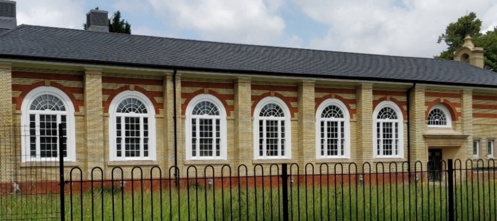 attractive single storey cream and red brick building with a line of large white windows