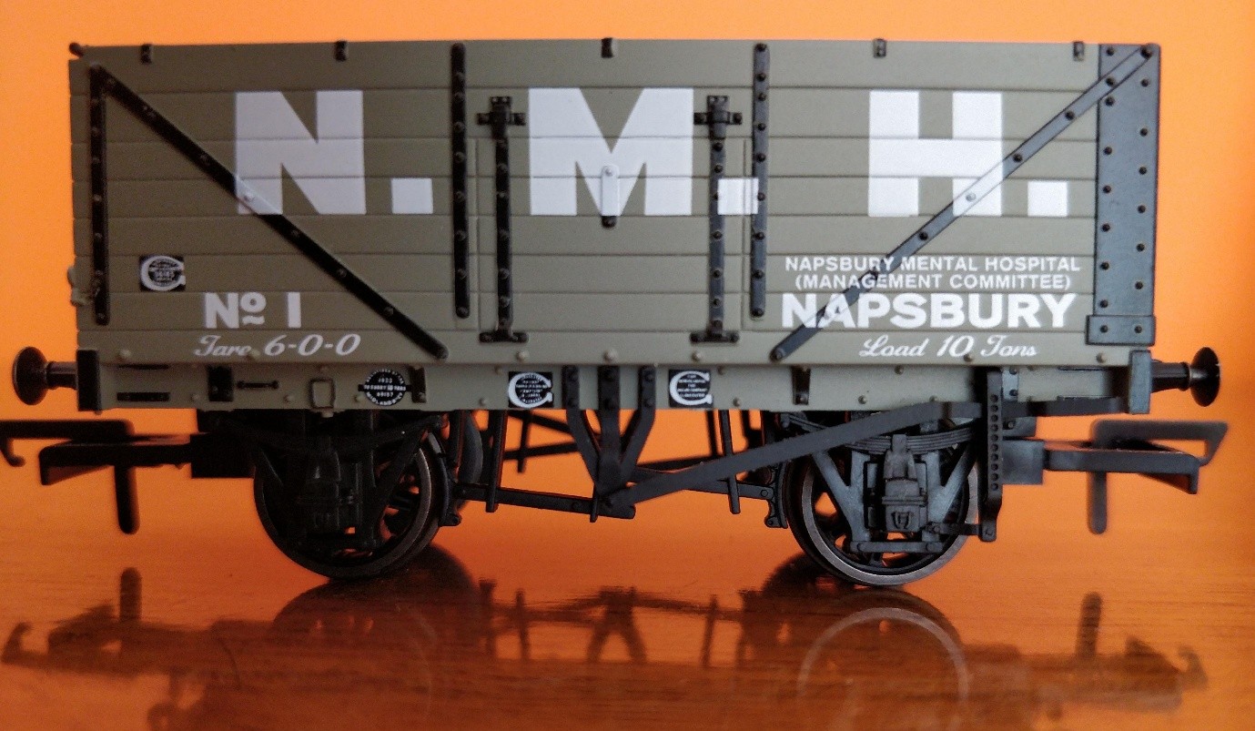 Photo of miniature Coal waggon (train) on a shiny surface. On the side it says Napsbury Mental Hospital Management Committee.