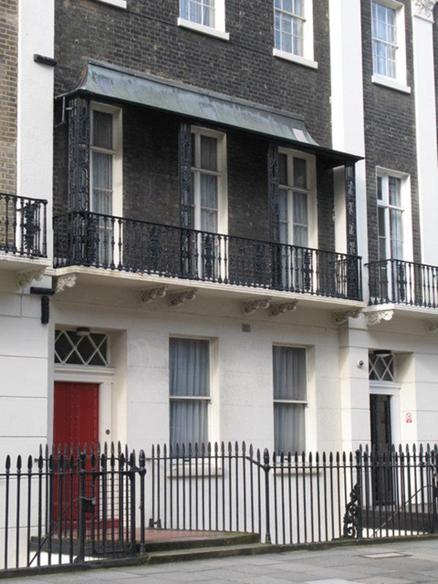 Terraced brick house with a red door.