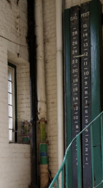 Interior showing white washed brick and a white on black list of numbers up one wall